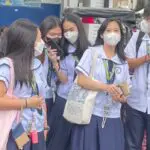 A group of people wearing masks and taking pictures.