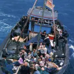 A boat full of people is in the ocean.