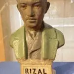 A bust of rizal is displayed on the table.