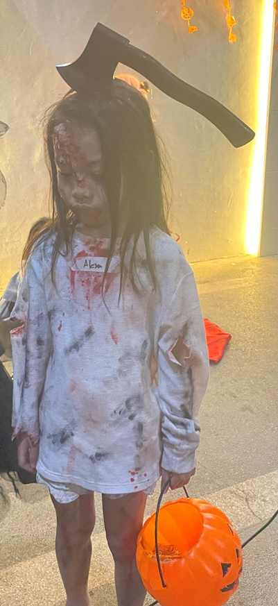 A young girl dressed as a zombie for halloween.