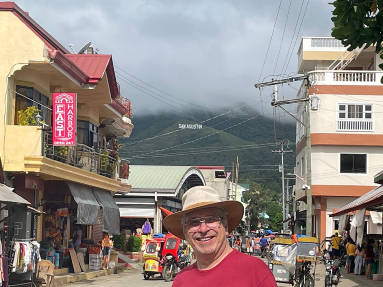 A man in a hat standing on the side of a street.