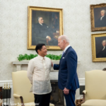 A man in a suit and tie standing next to another man.