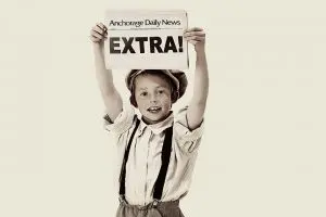 A young boy holding up an extra sign.