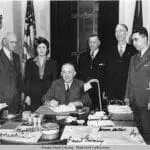 A group of people standing around a table.