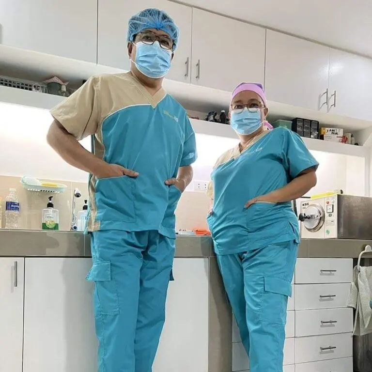 Two doctors standing in a room with their hands on their hips.