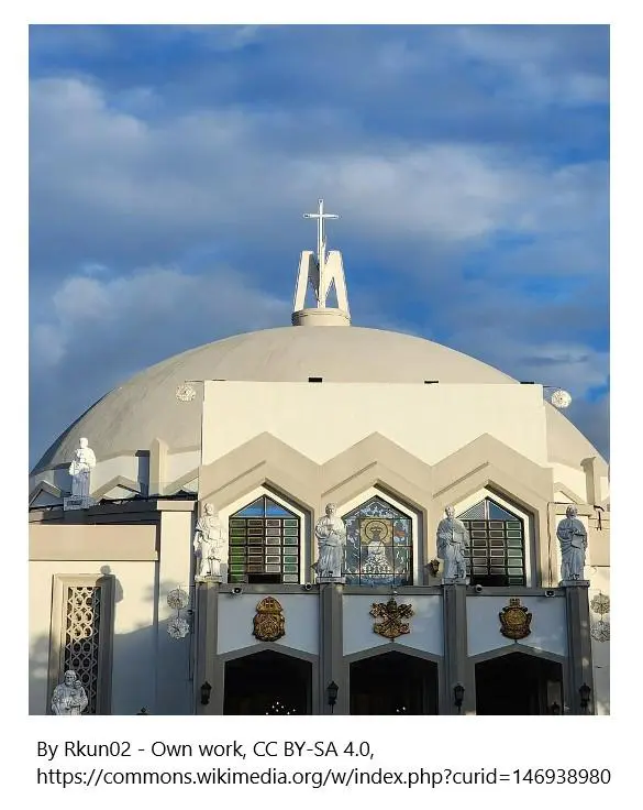 A large white building with a cross on top of it.