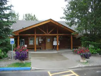 A building with a large porch and lots of flowers.