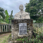 A statue of a man in the middle of a garden.