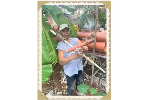 Man holding tools among construction materials.