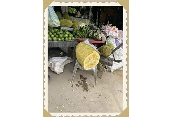 Market stall with fruits and vegetables displayed.