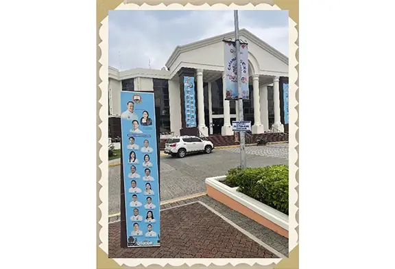 Promotional banner outside a government building.