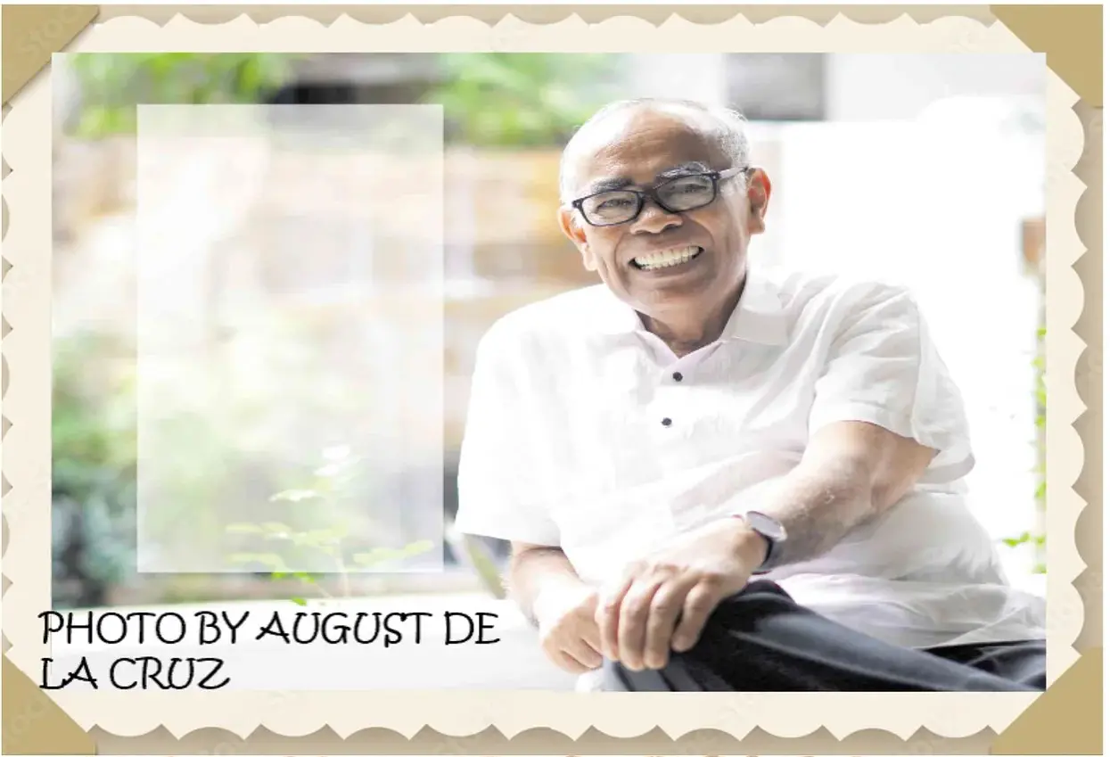 Smiling elderly man sitting outdoors.