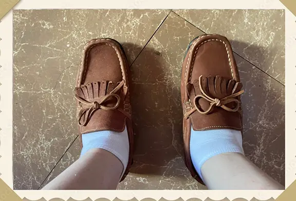 Brown moccasin shoes with white socks.