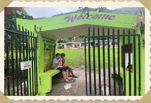 Boys sitting at a colorful bus stop.