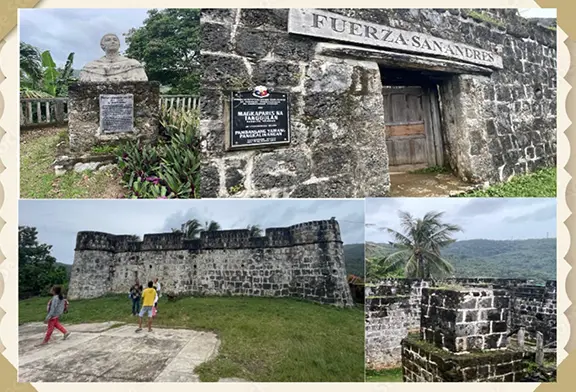 Historic fort with visitors and surrounding landscape.