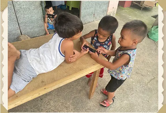 Children sharing a phone while playing together.