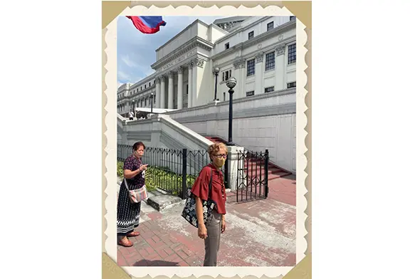 Two people walking near a building.