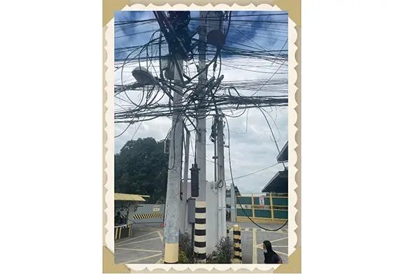 Utility poles with tangled wires and cables.