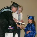 Graduation ceremony with a smiling child.