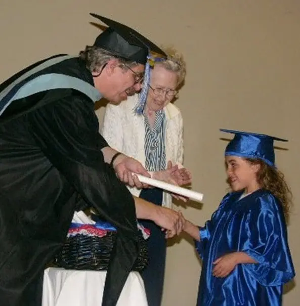 Graduation ceremony with a smiling child.