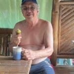 A man sitting at a table with an apple.