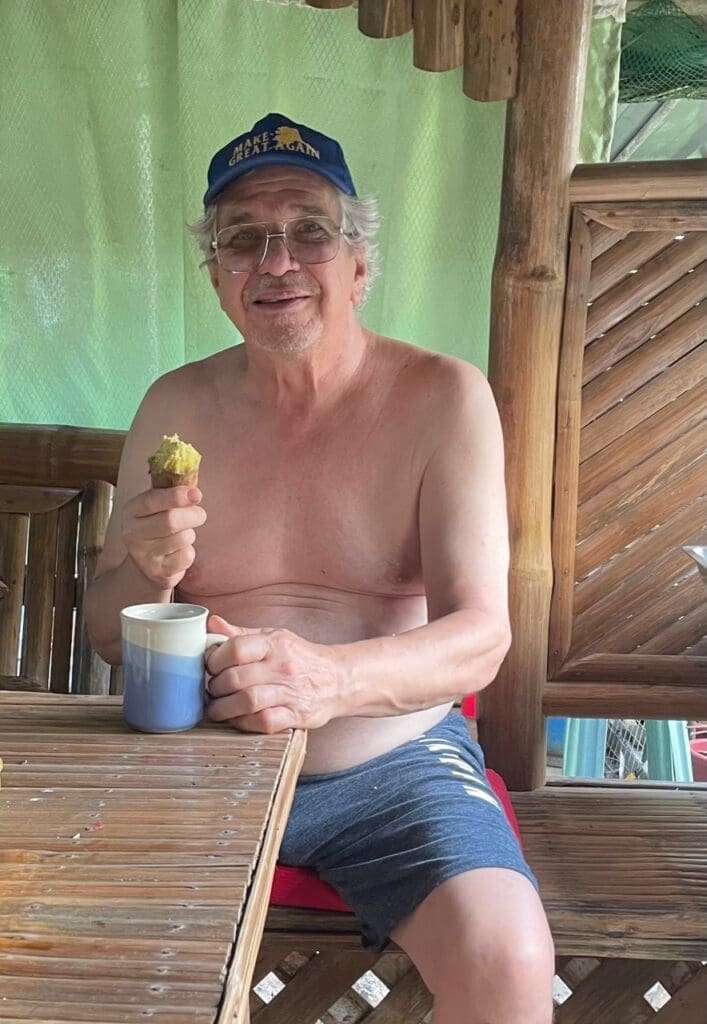 A man sitting at a table with an apple.