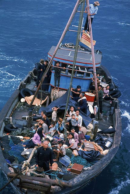 A boat full of people is in the ocean.