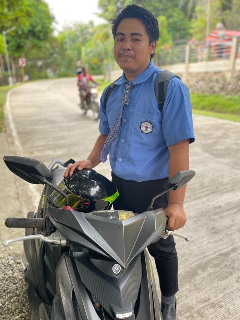 Man in blue shirt with a motorbike.