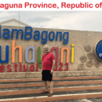 A man standing in front of a sign for the guam bagong buhayani festival.