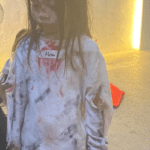 A young girl dressed as a zombie for halloween.