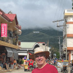 A man in a hat standing on the side of a street.