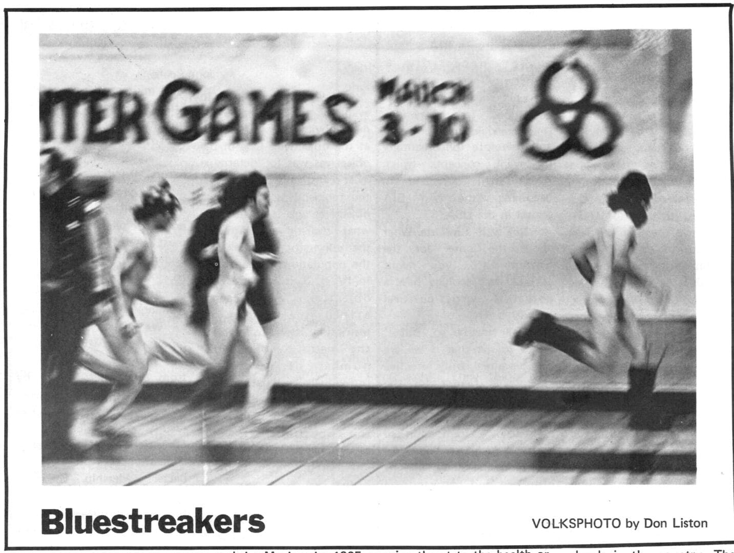 A group of men running in front of a wall.