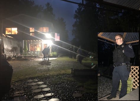 A man standing on the tracks in front of a house.