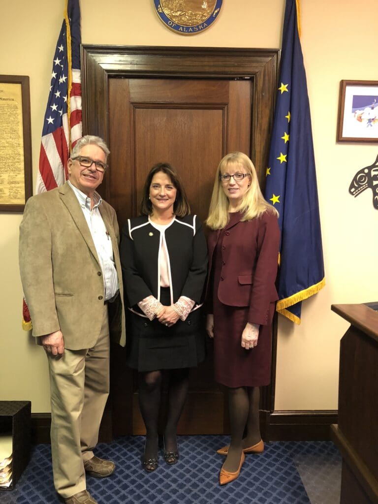 Three people standing in front of a door.